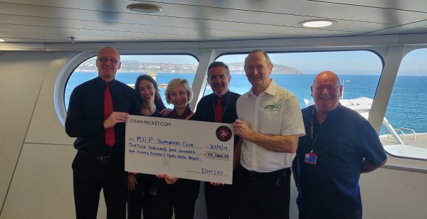 Allan Brew, MGP Supporters Club chairman, receives the cheque from IOMSPC crew members